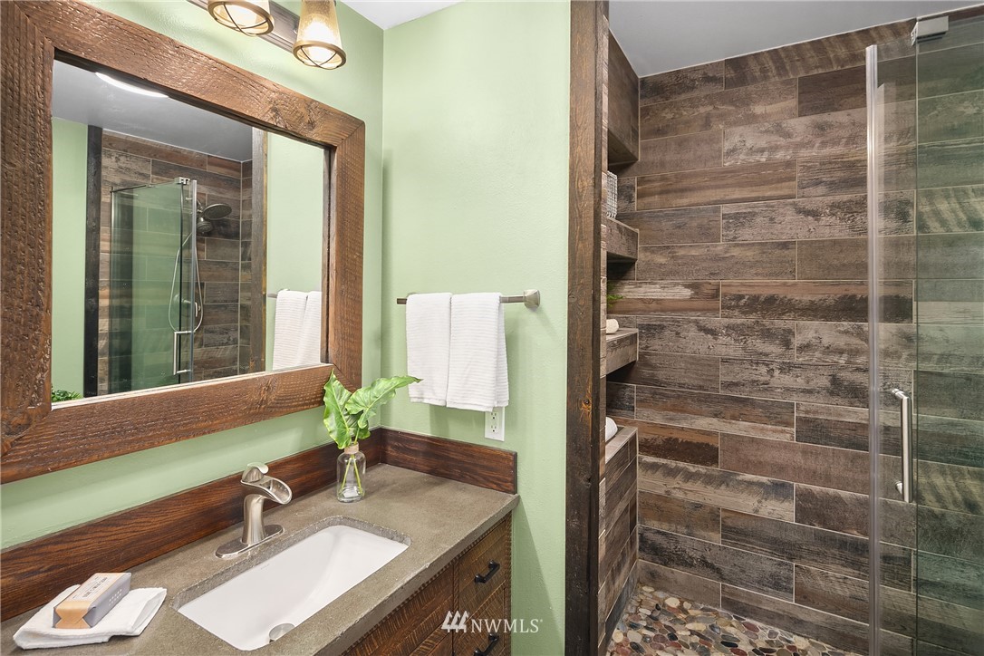 116 11th Avenue East, Unit 402 Seattle, WA 98102 - Photo 15 of 22 a bathroom with a granite countertop sink a mirror and shower