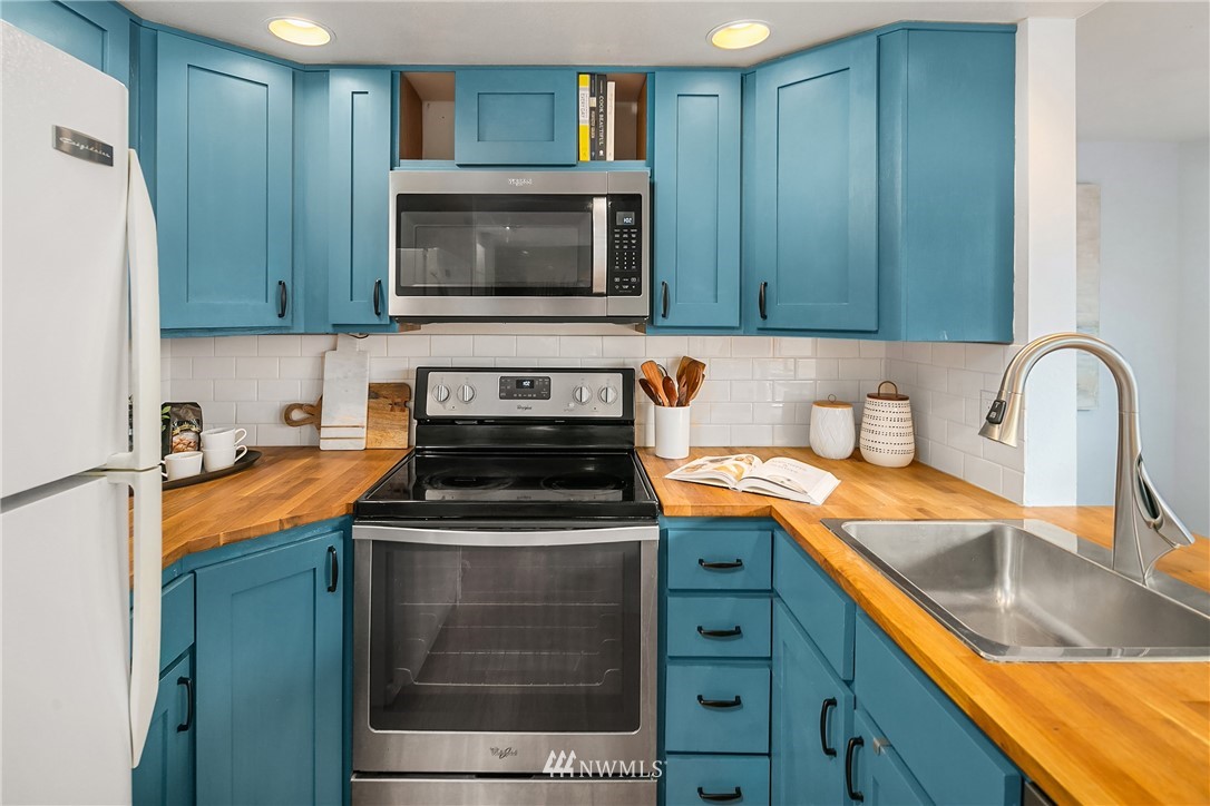 116 11th Avenue East, Unit 402 Seattle, WA 98102 - Photo 6 of 22 a kitchen with stainless steel appliances granite countertop a sink stove and microwave