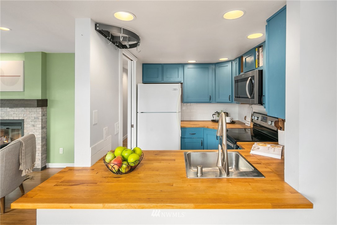 116 11th Avenue East, Unit 402 Seattle, WA 98102 - Photo 7 of 22 a kitchen with stainless steel appliances granite countertop a sink and a refrigerator