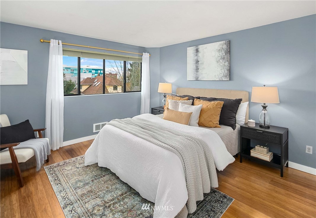 116 11th Avenue East, Unit 402 Seattle, WA 98102 - Photo 10 of 22 a bedroom with a bed and wooden floor