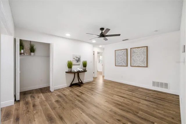a view of a livingroom with a hardwood floor and a ceiling fan