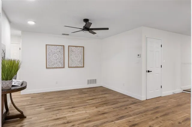 a view of empty room with wooden floor