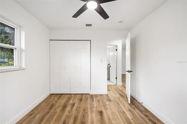 a view of empty room with wooden floor