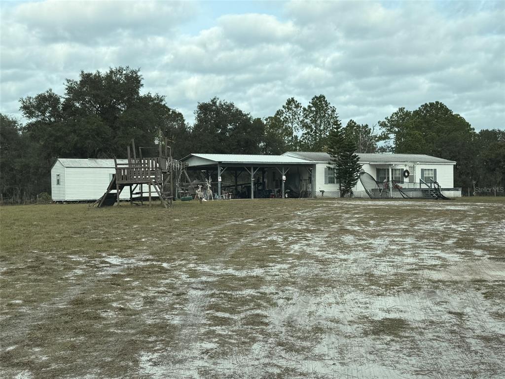 29605 Fullerville Road DeLand, FL 32720 - Photo 24 of 37 a front view of a house with a garden and lake view