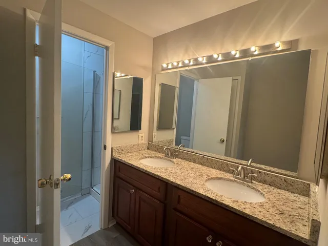 a bathroom with a granite countertop sink and a mirror
