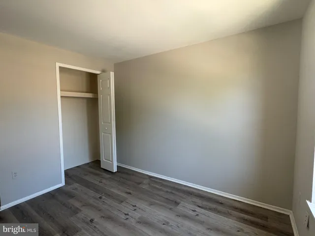 an empty room with wooden floor and closet