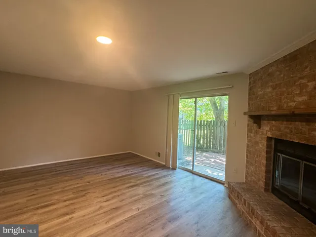 an empty room with wooden floor and fireplace