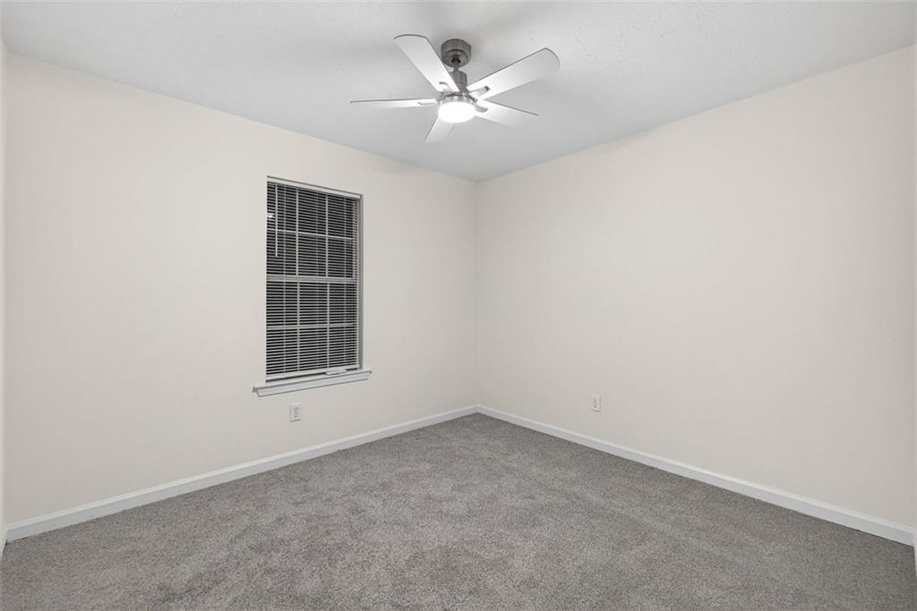 37 Peach Forest Way Douglasville, GA 30134 - Photo 20 of 30 an empty room with a chandelier fan and windows