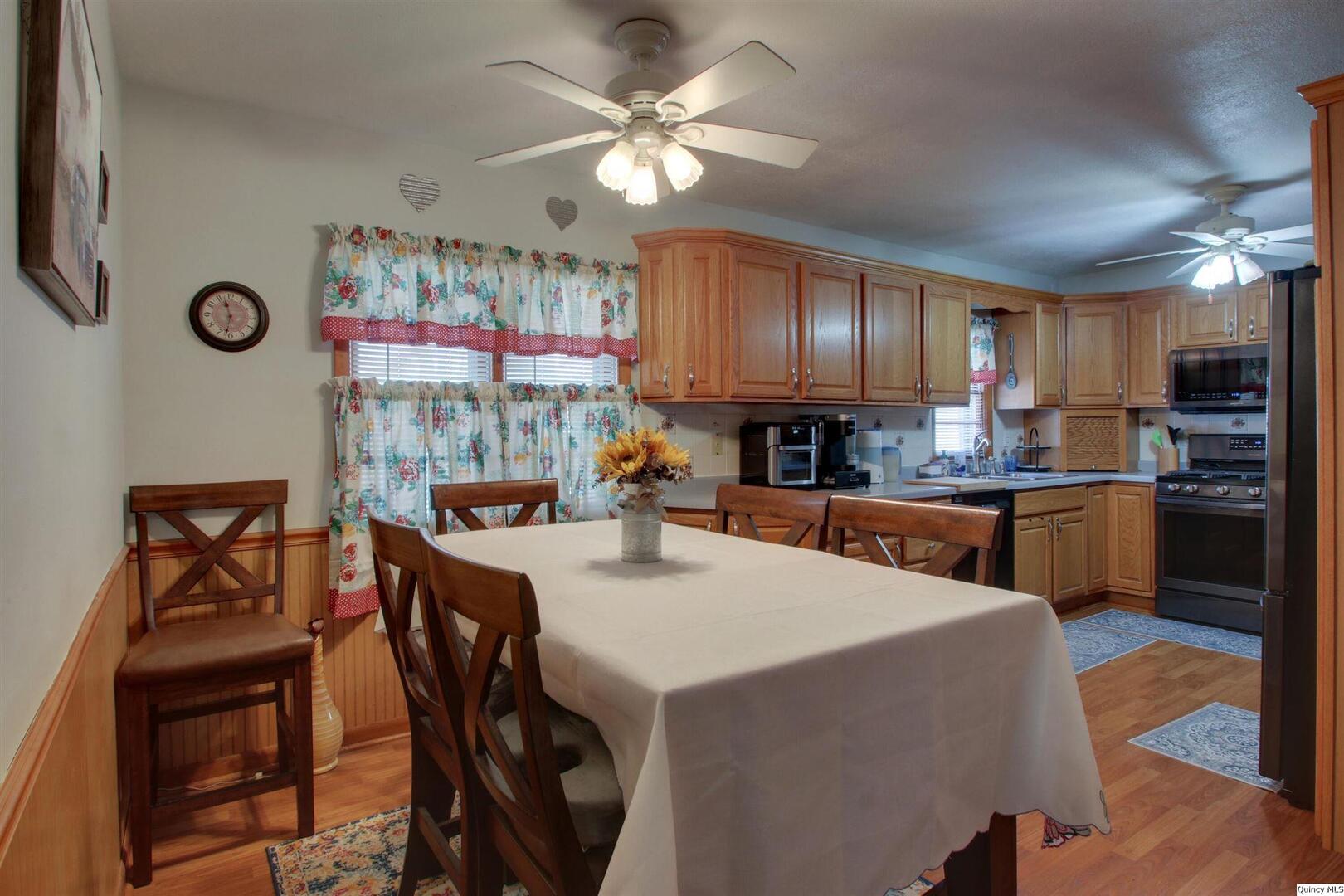 3608 Columbus Road Quincy, IL 62305 - Photo 5 of 17 a kitchen with kitchen island a stove a table and chairs in it
