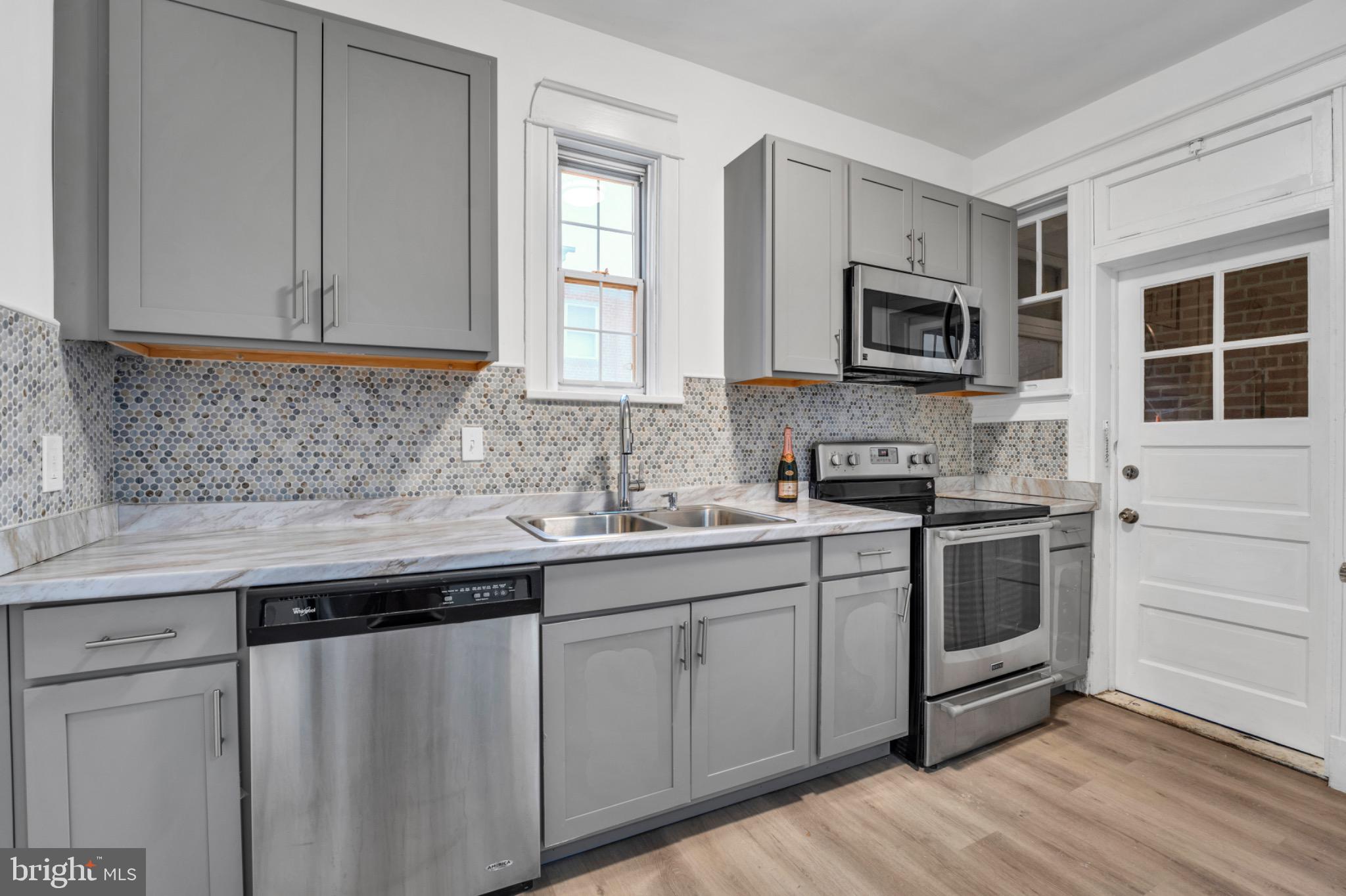 2219 Chesterfield Avenue Baltimore, MD 21213 - Photo 12 of 30 Modern kitchen with sleek gray cabinetry.
