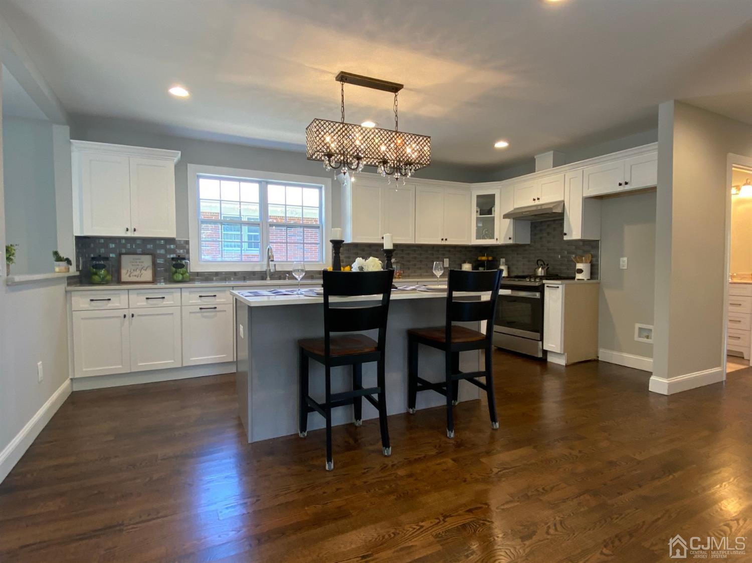 99 Jordan Road Colonia, NJ 07067 - Photo 20 of 53 a kitchen with stainless steel appliances kitchen island granite countertop a table chairs sink and cabinets