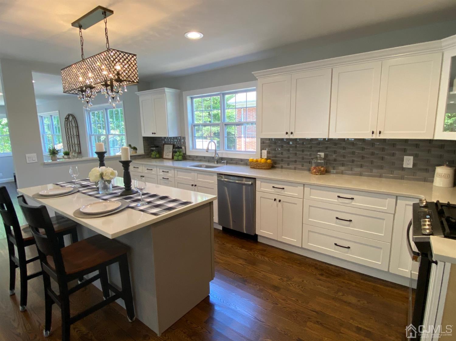 99 Jordan Road Colonia, NJ 07067 - Photo 21 of 53 a kitchen with a stove a sink a dining table and chairs