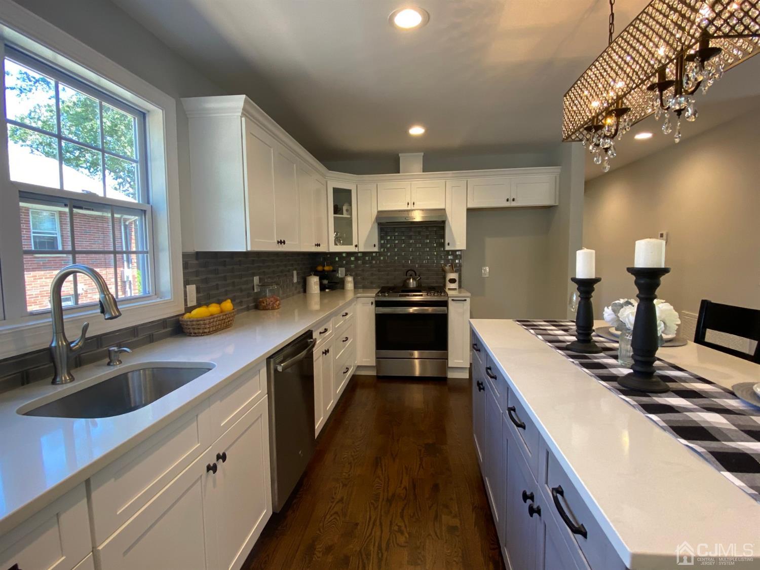 99 Jordan Road Colonia, NJ 07067 - Photo 31 of 53 a kitchen with kitchen island granite countertop a sink appliances cabinets and a counter top space
