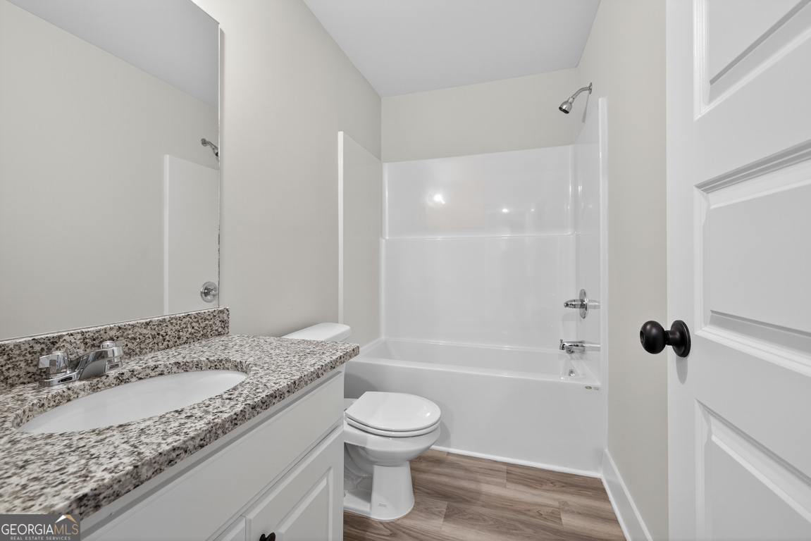 271 Mockingbird Lane, Unit 20 Winder, GA 30680 - Photo 25 of 38 a bathroom with a granite countertop sink a toilet and shower
