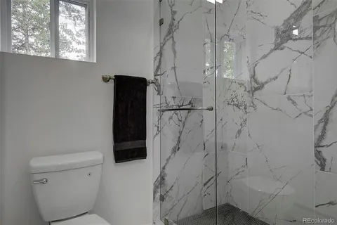 a bathroom with a granite countertop sink and a window