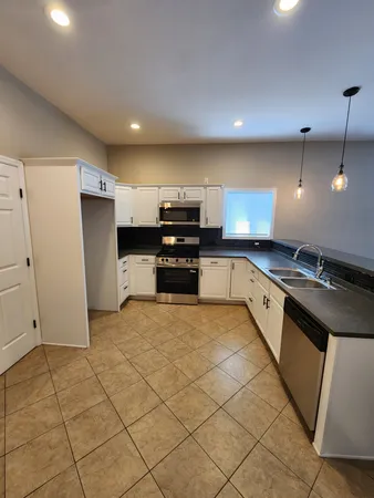 an empty room with wooden floor fireplace and windows