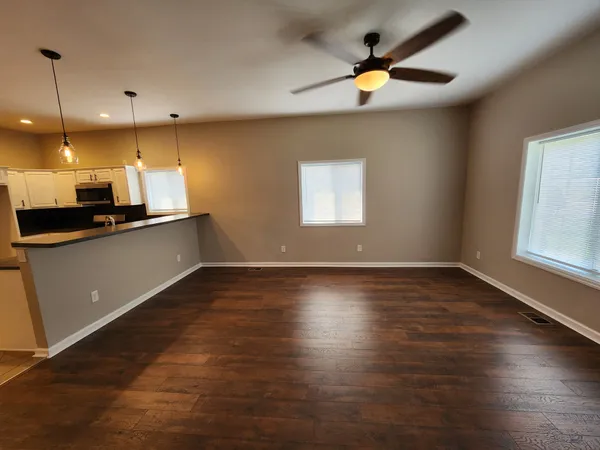 a view of an empty room with a ceiling fan and window