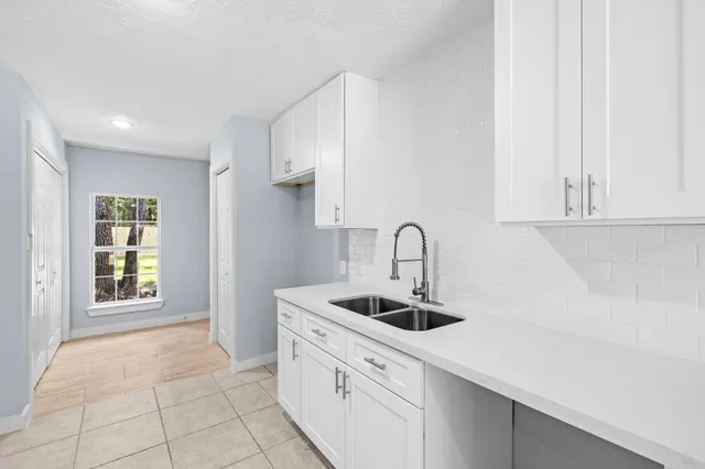 a kitchen with stainless steel appliances granite countertop a sink a stove and white cabinets