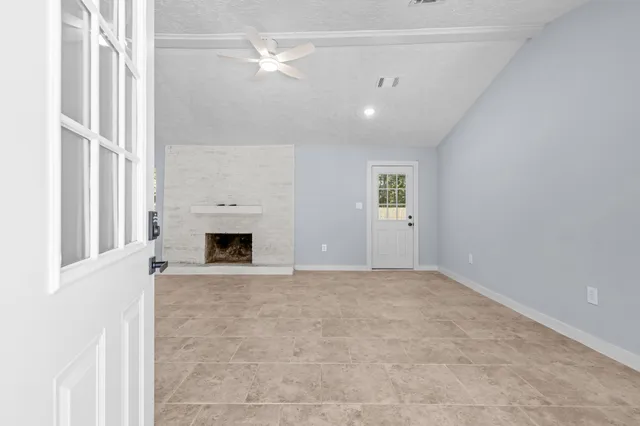 a view of a livingroom with a fireplace and window