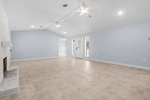 an empty room with a ceiling fan and window