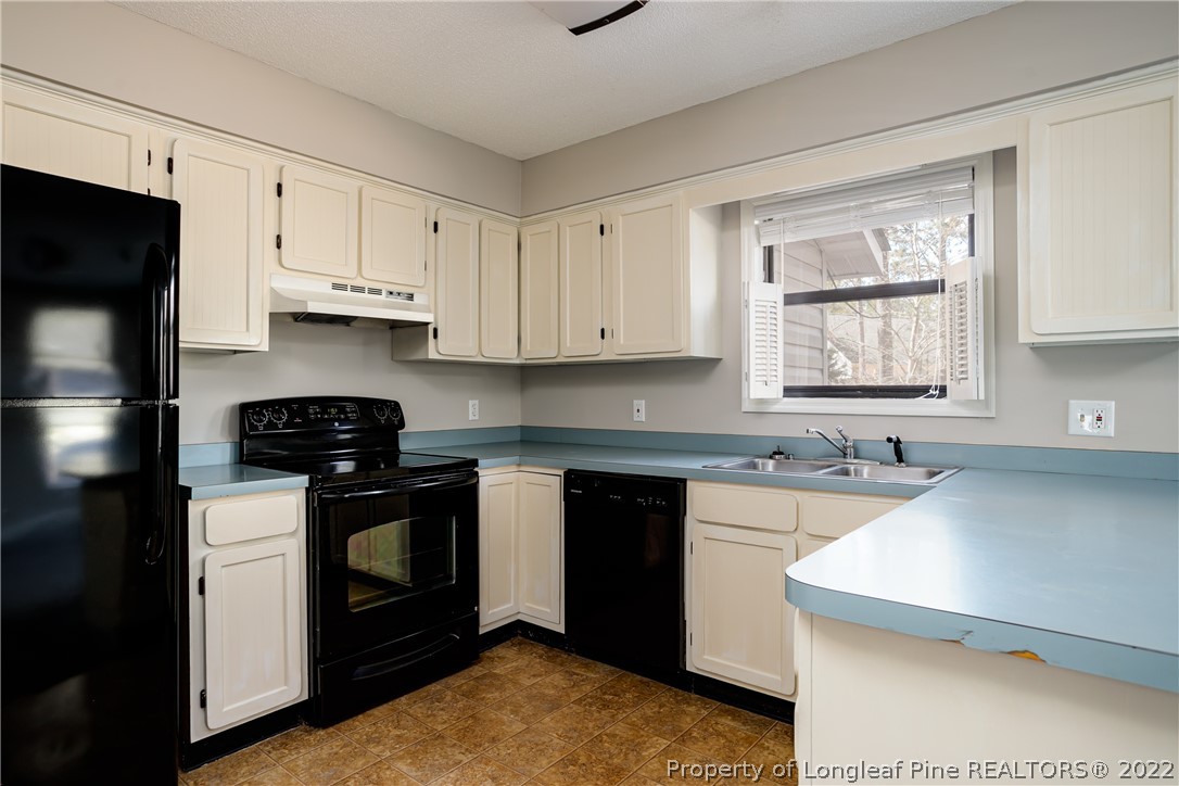 215 Fox Run Road Pinehurst, NC 28374 - Photo 11 of 24 a kitchen with stainless steel appliances granite countertop a sink stove and refrigerator