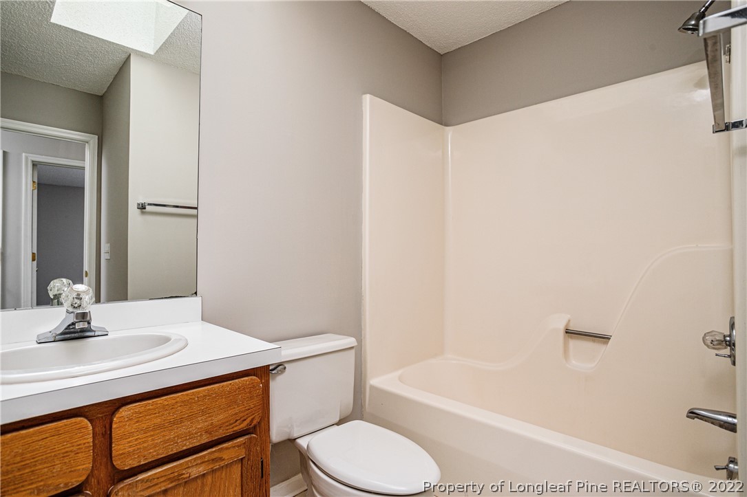 215 Fox Run Road Pinehurst, NC 28374 - Photo 17 of 24 a bathroom with a sink a toilet and bathtub