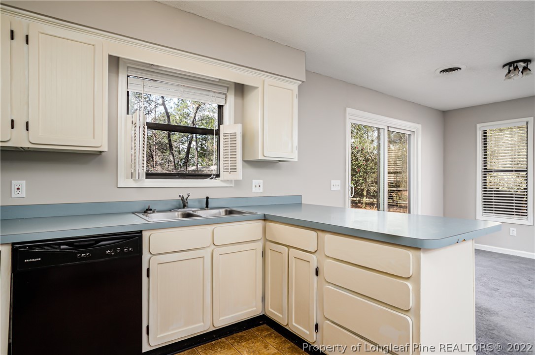 215 Fox Run Road Pinehurst, NC 28374 - Photo 9 of 24 a kitchen with granite countertop white cabinets and a window