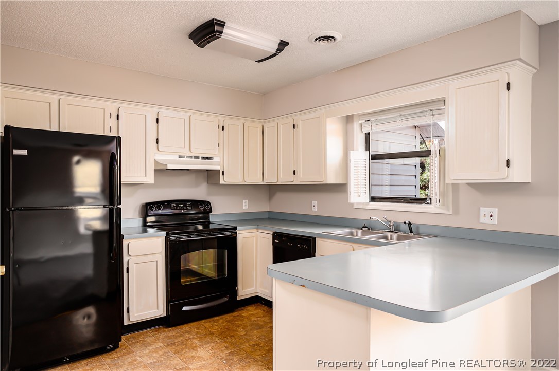 215 Fox Run Road Pinehurst, NC 28374 - Photo 10 of 24 a kitchen with a sink stove and refrigerator