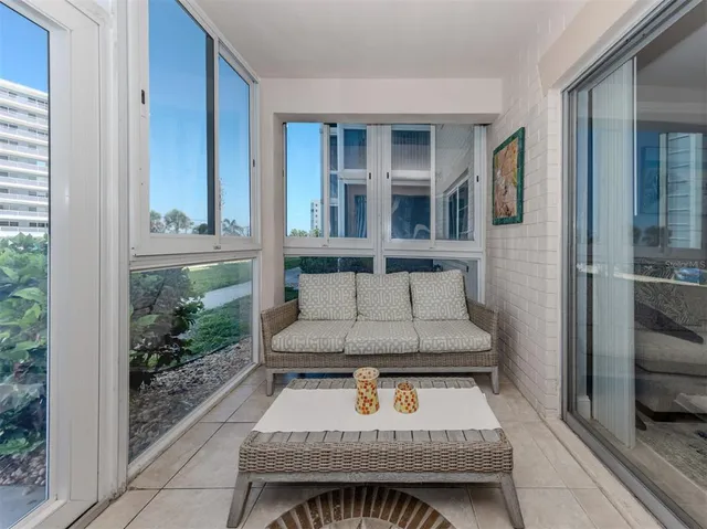 a living room with furniture a flat screen tv and windows