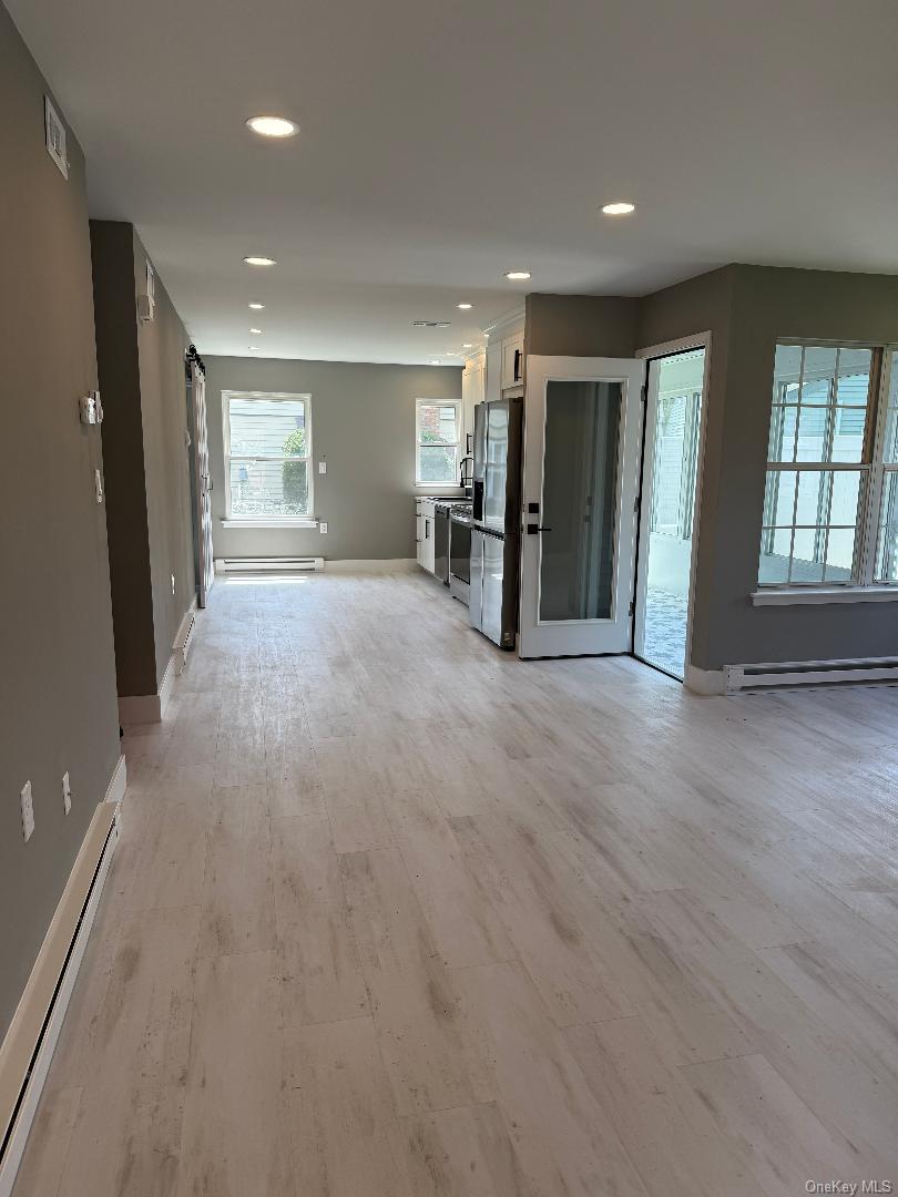 379 Larchmont Court Ridge, NY 11961 - Photo 2 of 17 an empty room with furniture and windows
