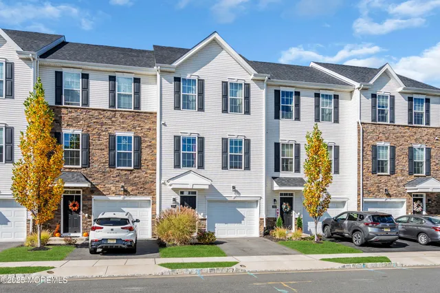 a car parked in front of a brick house with a yard