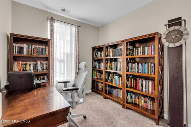 a view of a livingroom with a bookshelf and a workspace