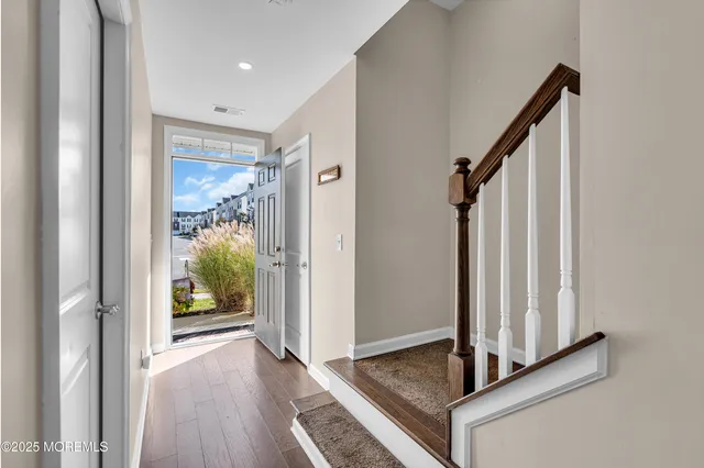 a view of a hallway with wooden floor and staircase