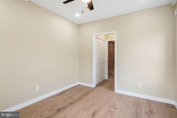 921 South Alden Street Philadelphia, PA 19143 - Photo 16 of 28 an empty room with wooden floor and a ceiling fan