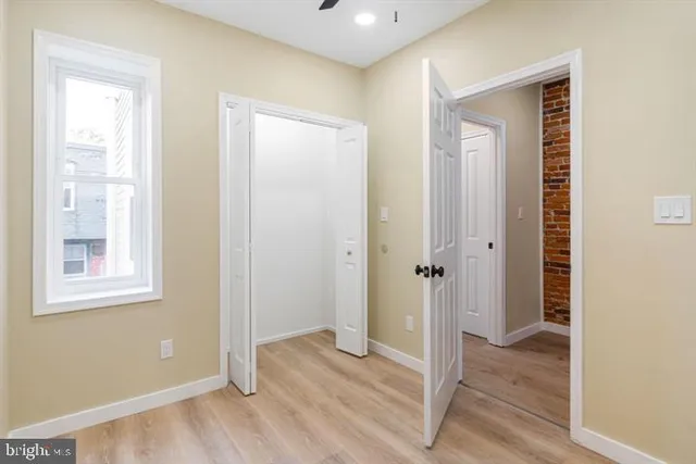 an empty room with wooden floor and window