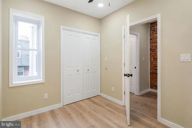 an empty room with closet and windows