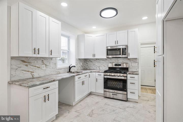 921 South Alden Street Philadelphia, PA 19143 - Photo 8 of 28 a kitchen with granite countertop white cabinets and stainless steel appliances