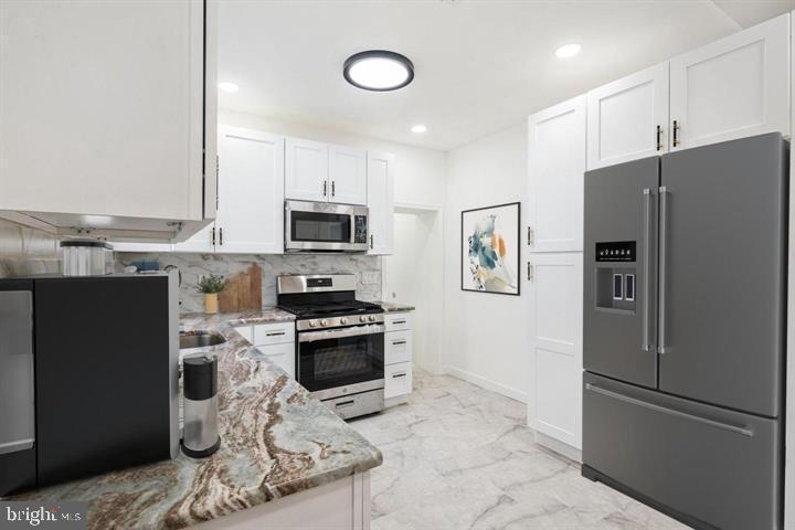 921 South Alden Street Philadelphia, PA 19143 - Photo 9 of 28 a kitchen with stainless steel appliances granite countertop a refrigerator stove and microwave