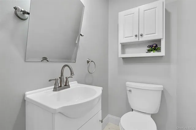 a bathroom with a toilet a sink and mirror