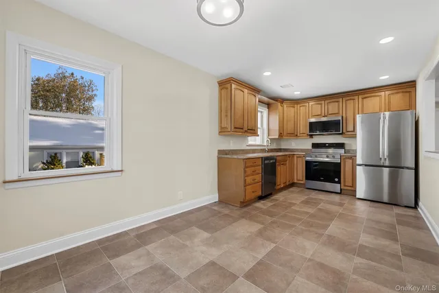 a kitchen with stainless steel appliances a refrigerator sink and microwave