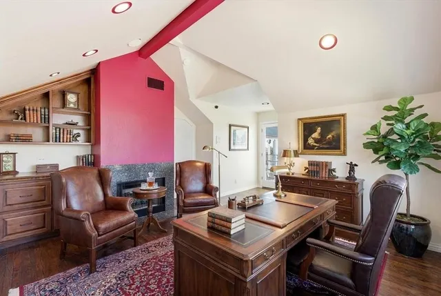 a view of empty room with fireplace and wooden floor