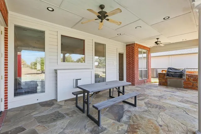 a view of a patio with couches chairs under an umbrella