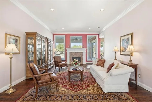 an empty room with wooden floor fireplace and windows