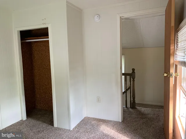 an empty room with windows and closet