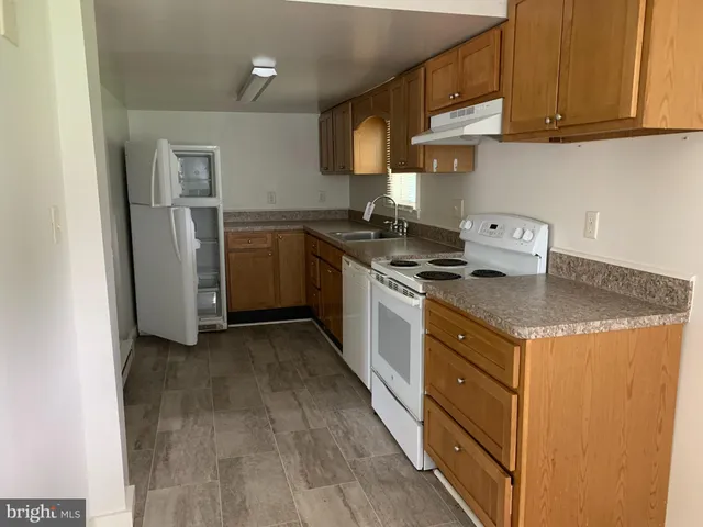 a kitchen with granite countertop a sink stove and refrigerator