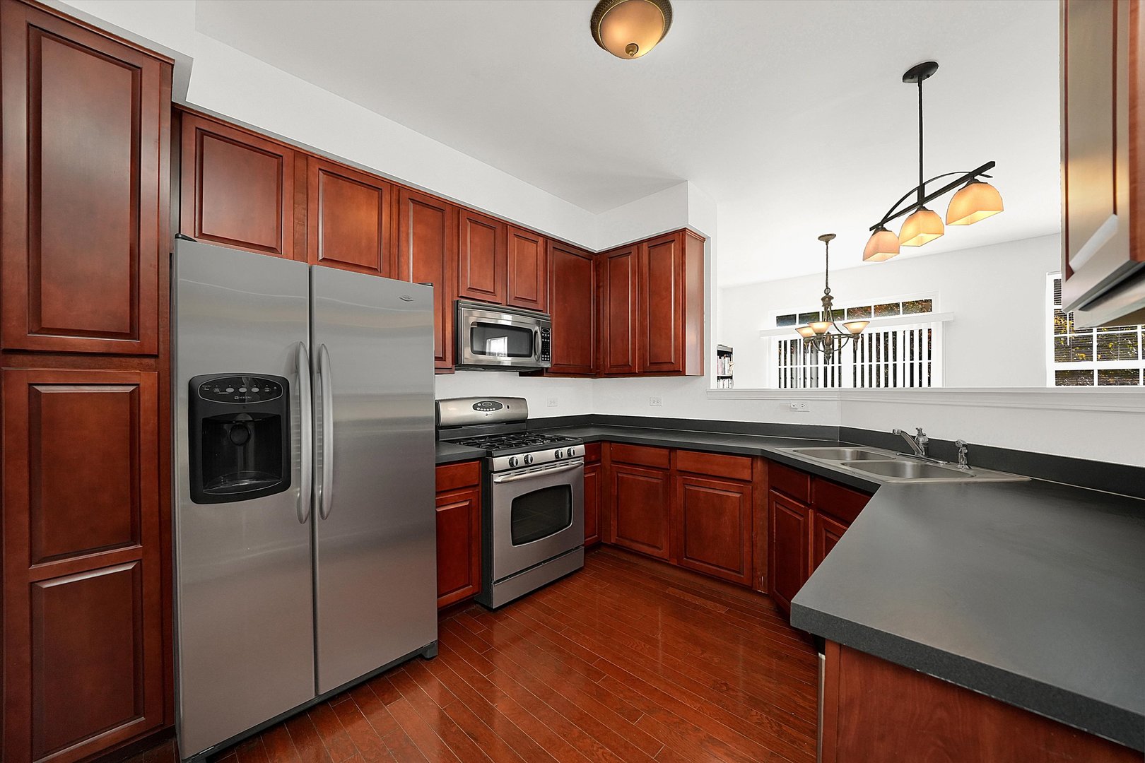 1956 West Cobblestone Road Romeoville, IL 60446 - Photo 3 of 14 a kitchen with stainless steel appliances granite countertop a refrigerator a sink dishwasher a stove and a microwave oven on granite countertops