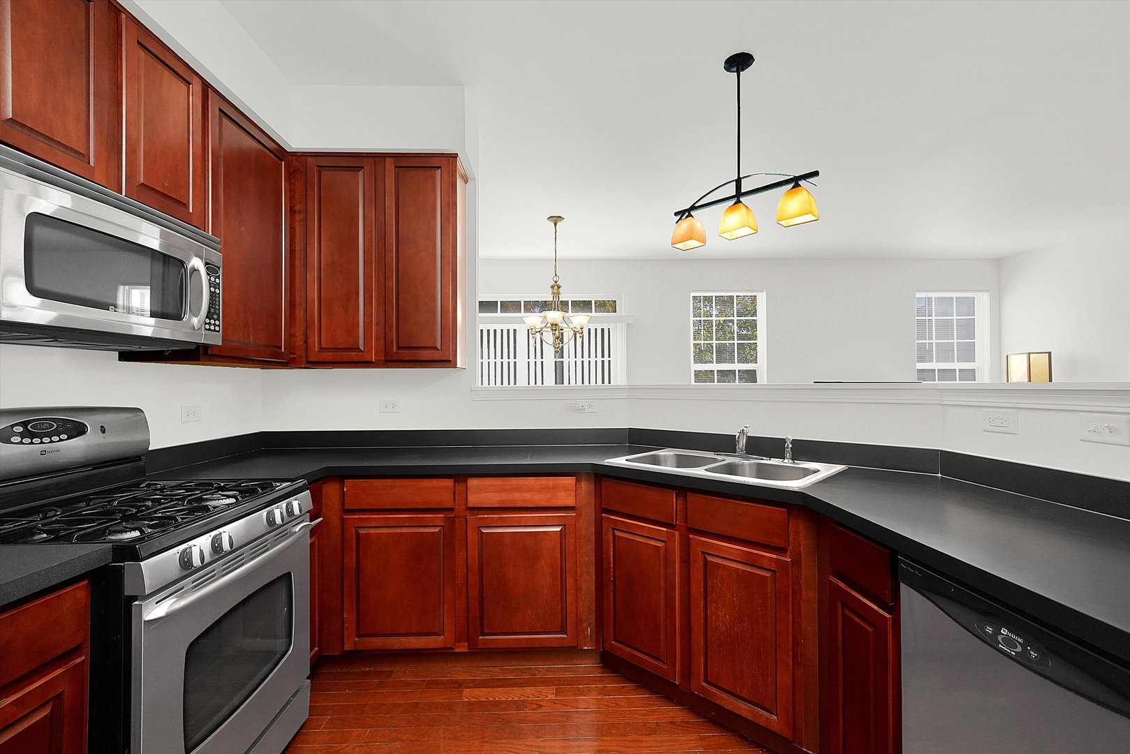 1956 West Cobblestone Road Romeoville, IL 60446 - Photo 4 of 14 a kitchen with stainless steel appliances granite countertop a sink a stove a microwave and wooden cabinets