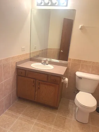 a bathroom with a toilet sink and mirror