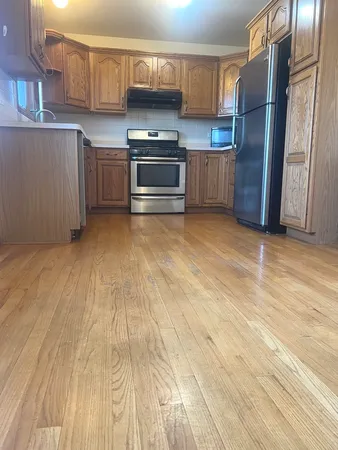 a kitchen with stainless steel appliances granite countertop a stove a sink and a refrigerator
