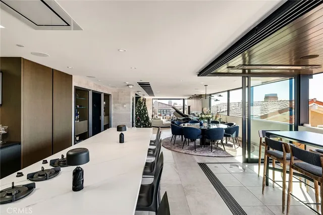 a living room with stainless steel appliances kitchen island granite countertop a stove and a sink